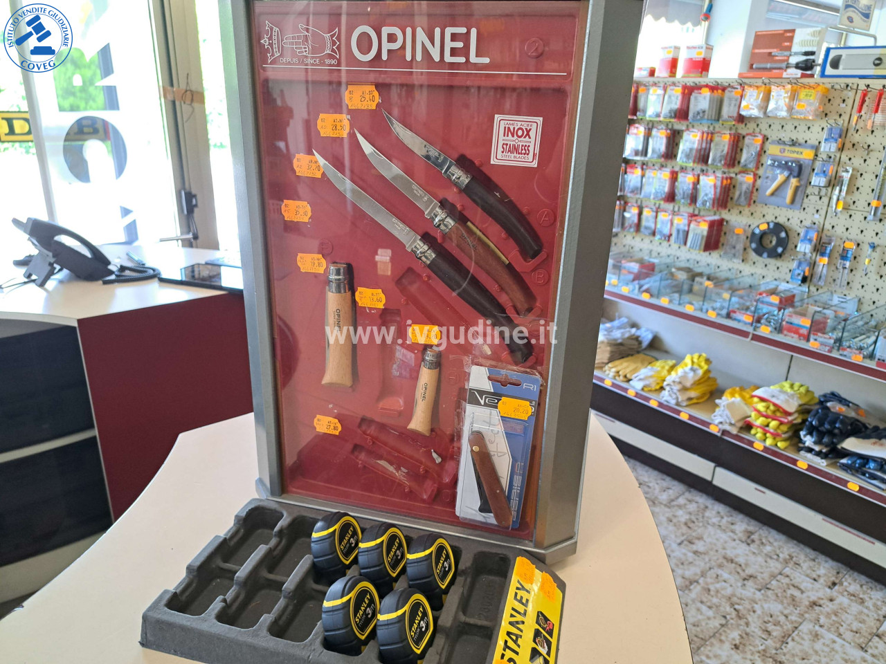 Foto 2 — (Lotto n.202) Espositore ferramenta: 8 coltelli Opinel, 5 flessometri Stanley, 2 cutter, 4 accendigas PROF, 3 accendini LUX, 9 occhiali lettura, 10 occhiali protettivi (NOS)